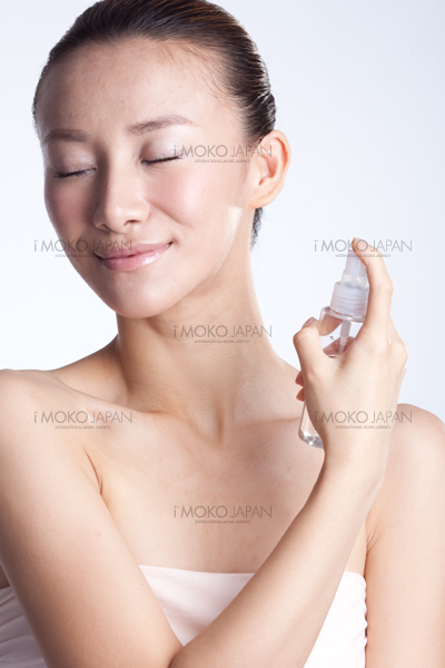水スプレーを顔にかける女性