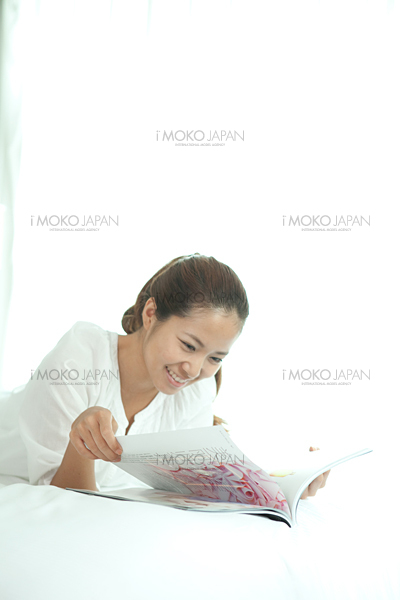 本 雑誌を読む 寝そべる 横になる 休日 プライベートタイムを過ごす 室内にいる女性 女性写真素材のビジンソザイ